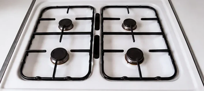 Same gas cooktop degreased back to clean white enamel and black grates