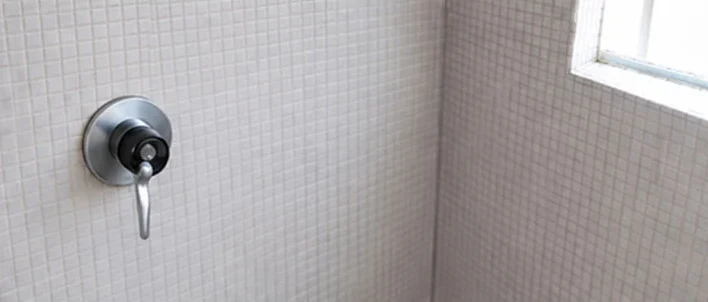Same shower tiles and grout bright and clean around the mixer tap