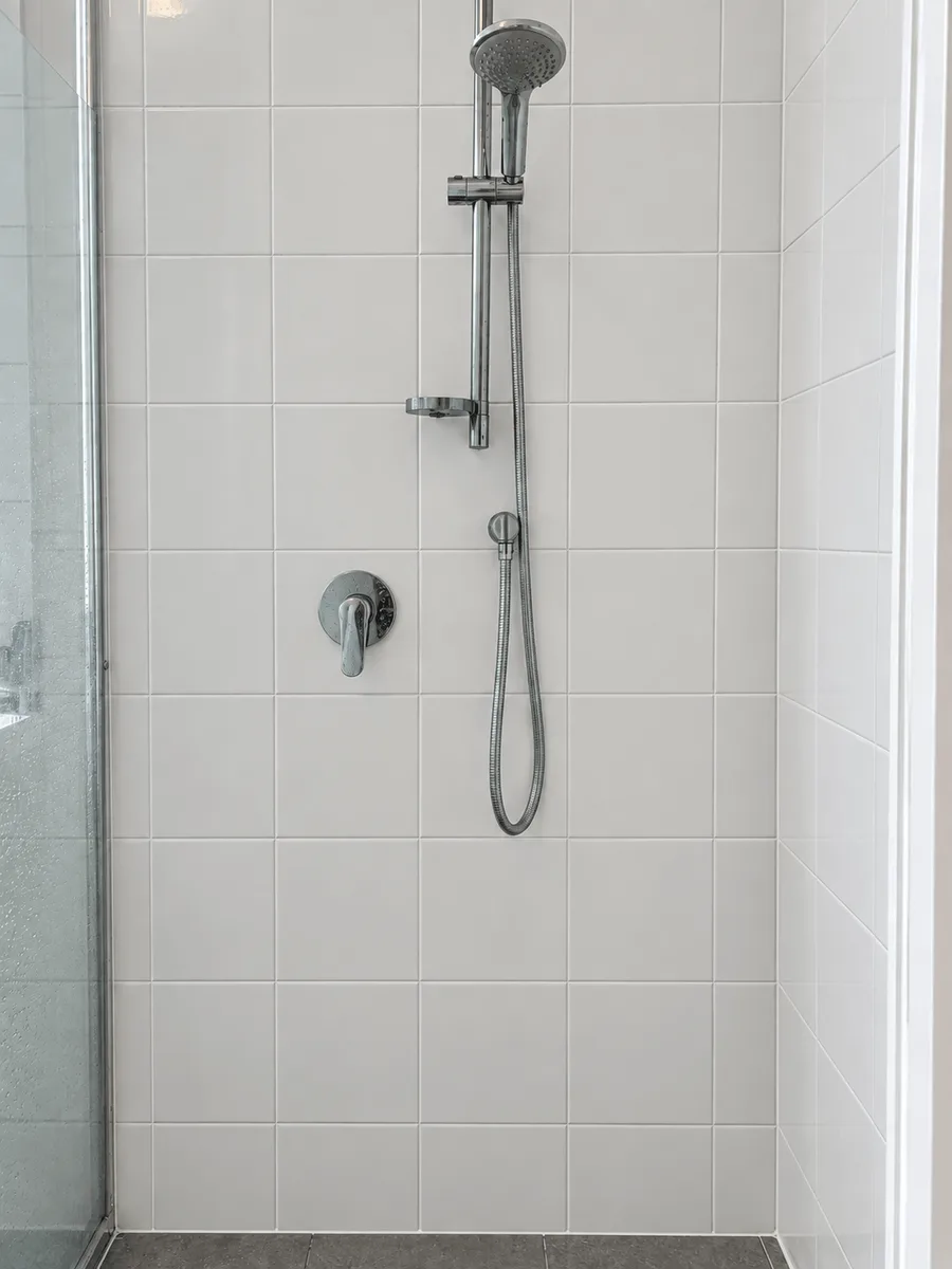 Same shower wall after tile and grout cleaning, with bright white grout lines and stain-free tiles
