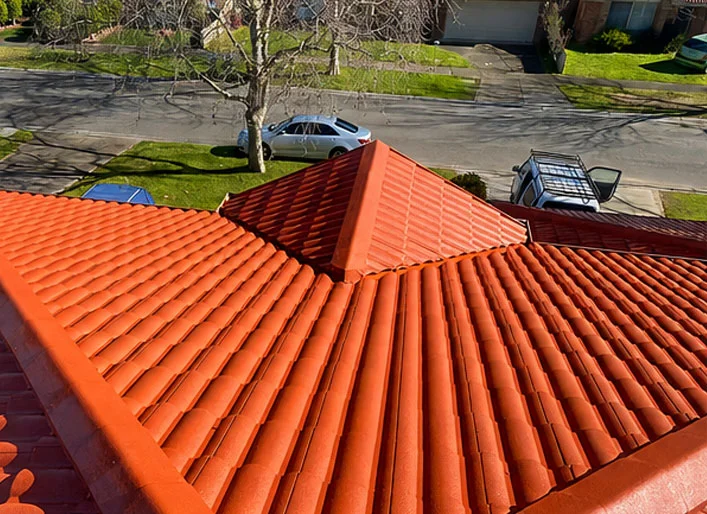 Same hip roof after cleaning and recoating the terracotta tiles in a glossy bright finish